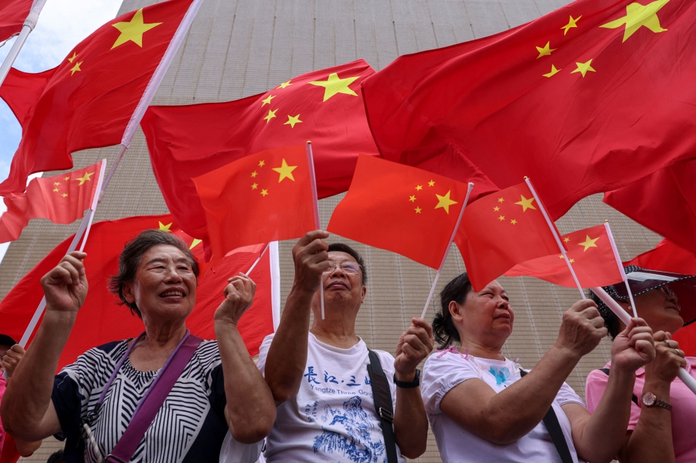 Pro-China supporters hold Chinese flags at an event celebrating the 28th anniversary of the former British colony’s handover to Chinese rule, in Hong Kong, China July 1, 2025. — Reuters pic 