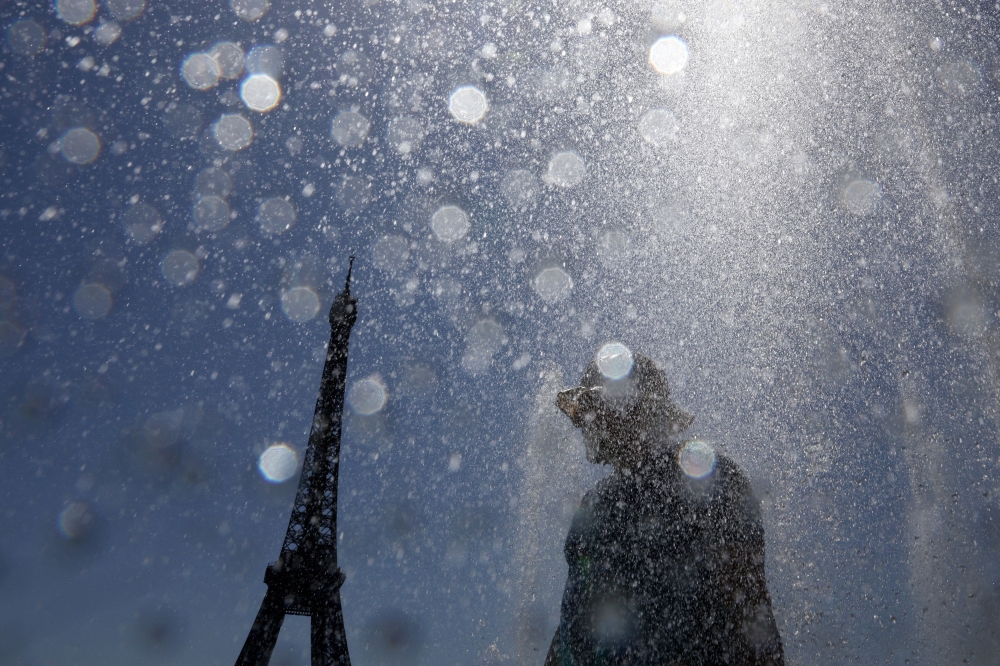 More than a thousand schools were closed in France on Tuesday and the top floor of the Eiffel Tower was shut to tourists as a severe heatwave continued to grip Europe, triggering health alerts across the region. — Reuters pic