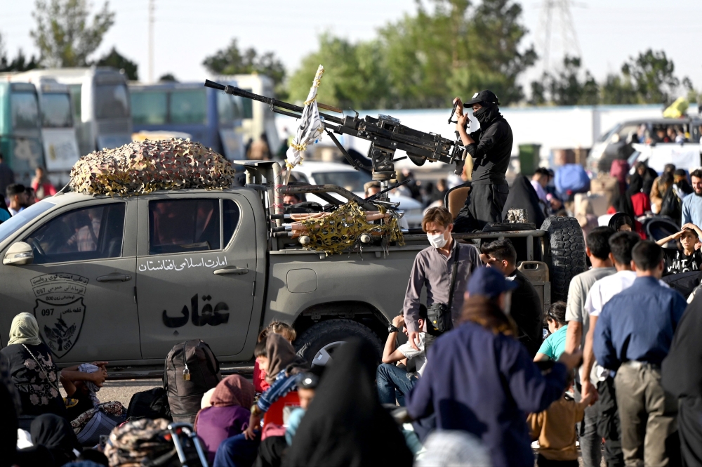 A Taliban security personnel stands on back of a vehicle as Afghan refugees arrive at the zero point of the Islam Qala border crossing between Afghanistan and Iran on June 28, 2025, following their deportation from Iran. — AFP pic