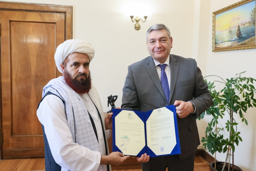 In this handout photo released by the Russian Foreign Ministry on July 3, 2025, the newly appointed Taliban envoy to Moscow Gul Hassan hands 