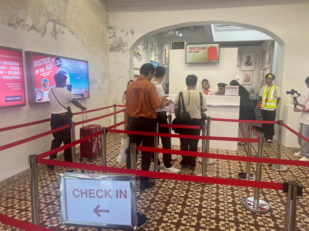 Visitors become part of the art installation by queuing and checking in as if at an airport. — Picture by Opalyn Mok