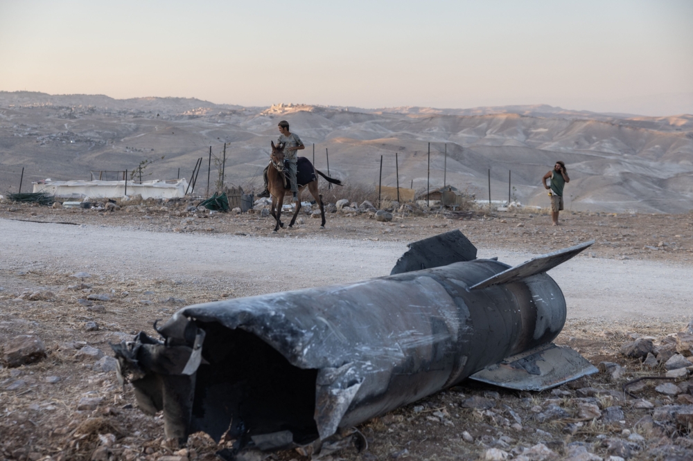 A man rides a horse next to the remains of an Iranian missile that fell an outpost near the Israeli settlement of Tekoa in the occupied West Bank, on 29 June 2025, in the aftermath of the 12-day war between Israel and Iran.  — AFP pic