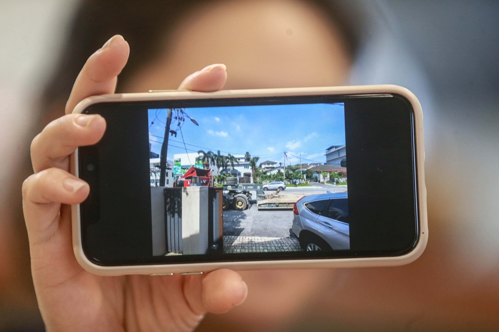 Mandy shows a photograph of a lorry blocking the entrance to her house at Lorong Maarof, Bangsar, Kuala Lumpur. — Picture by Sayuti Zainudin