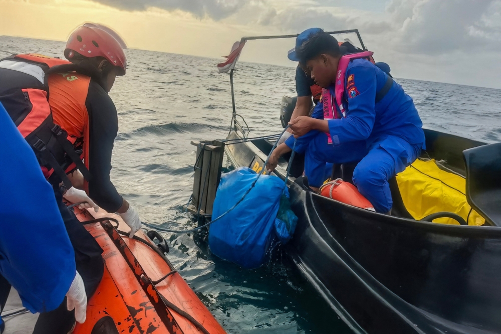 Indonesia's National Search and Rescue Agency (BASARNAS) personnel retrieve the bodies of suspected victims of the KMP Tunu Pratama Jaya off the Tanjung Anjir Sembulungan strait in Banyuwangi, East Java. — Reuters pic