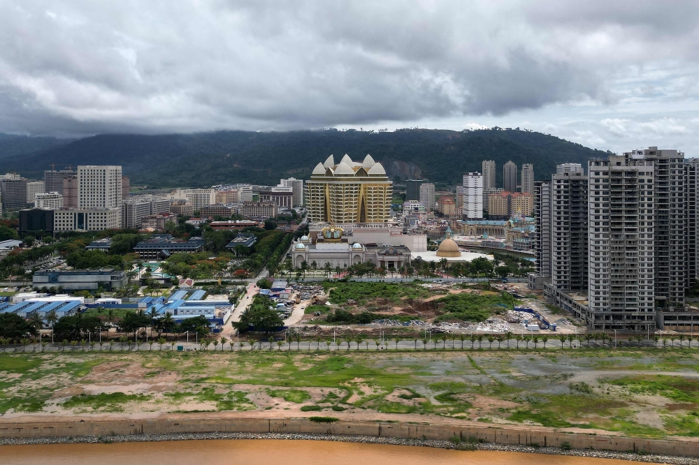 An aerial view of the Kings Romans Casino (centre) and high-rise buildings (right) inside the Golden Triangle Special Economic Zone in Laos, as seen across the Mekong River from Chiang Rai province, Thailand, May 26, 2025. Rising from muddy fields on the riverbank, a lotus tops the casino in a sprawling city that analysts say has become a hub for cybercrime. — AFP pic
