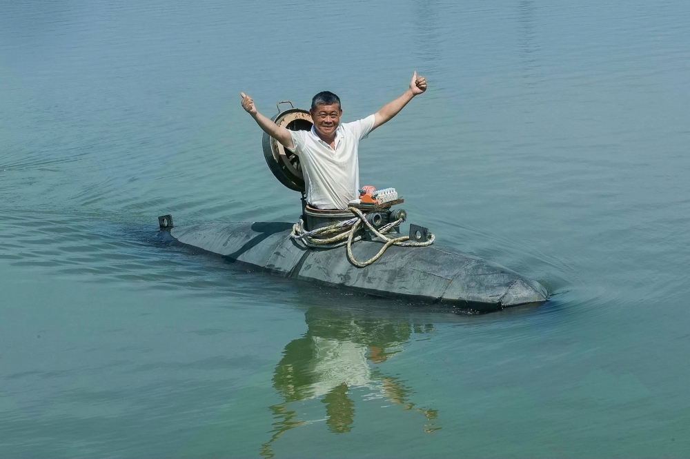 This photo taken on July 2, 2025 shows Chinese farmer Zhang Shengwu posing in his homemade submarine. — AFP pic