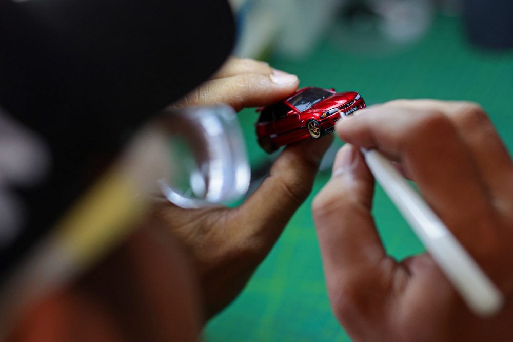 Printing machine technician Mohd Jaidin Mustafa details a 1:64 scale miniature car using tools. — Bernama pic