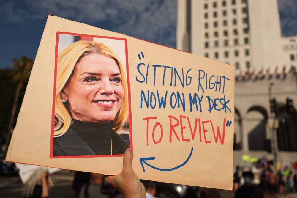 A protester holds a sign featuring a photo of US Attorney General Pam Bondi and a quote referencing the Epstein files during a ‘Good Trouble Lives On’ demonstration against the Trump administration in Los Angeles on July 17, 2025. — AFP pic