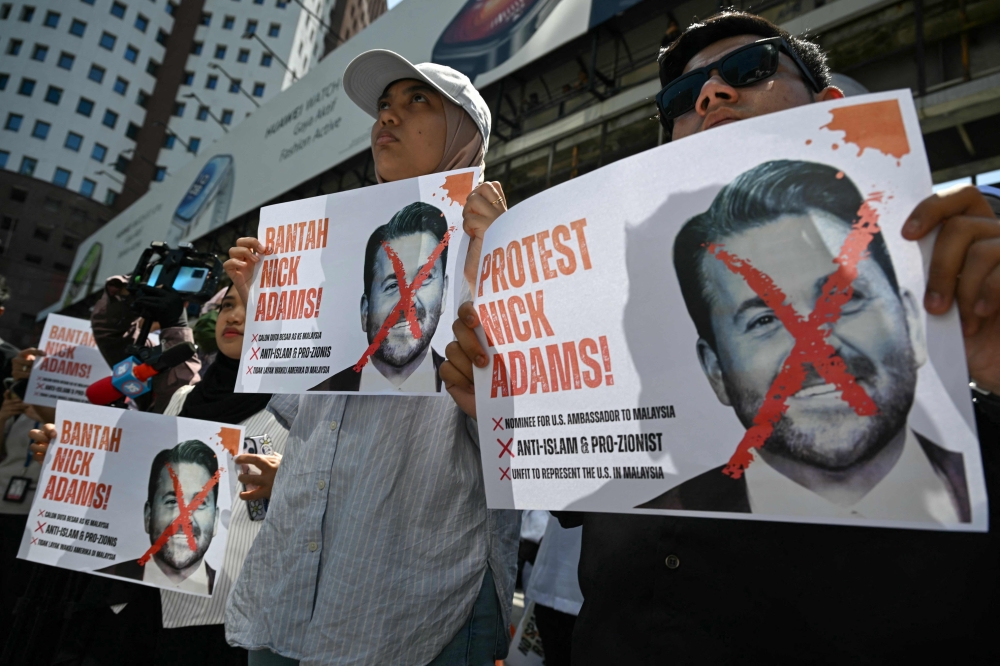 Malaysian protesters display placards during a demonstration against the US envoy nominee Nick Adams outside the US embassy in Kuala Lumpur on July 18, 2025. — AFP pic