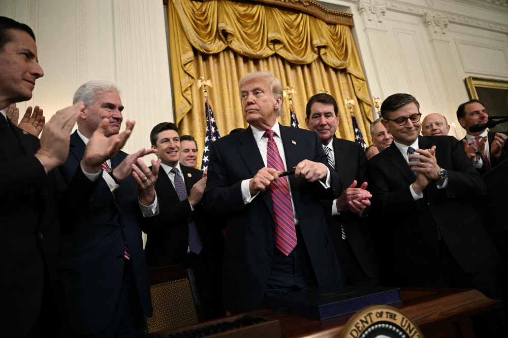 US President Donald Trump prepares to sign the Genius Act (Guiding and Establishing National Innovation for US Stablecoins Act), which codifies the use of stablecoins in the East Room of the White House in Washington, DC, on July 18, 2025. — AFP pic