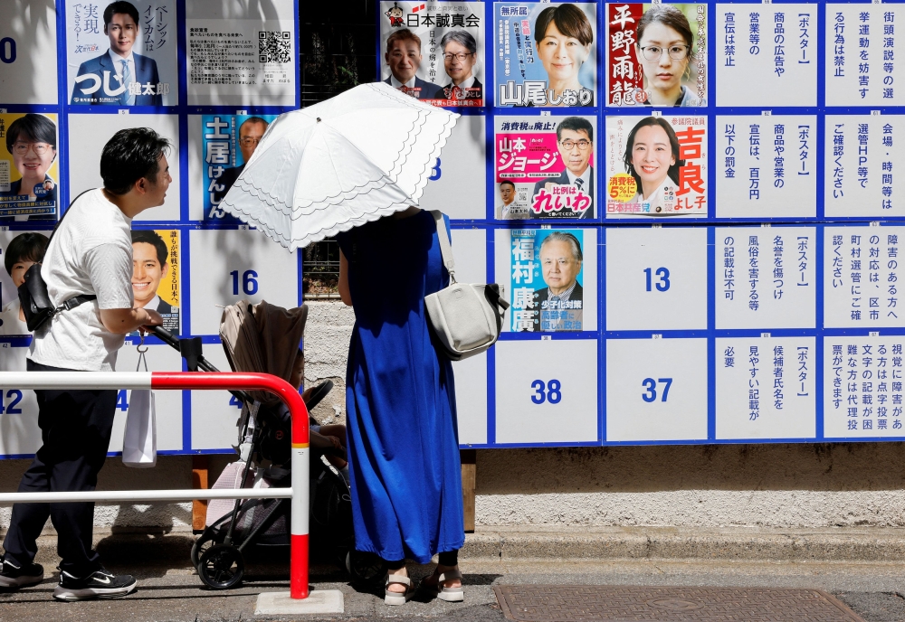 Japanese voters headed to the polls on Sunday in a tightly contested upper house election that could unleash political turmoil. — Reuters pic