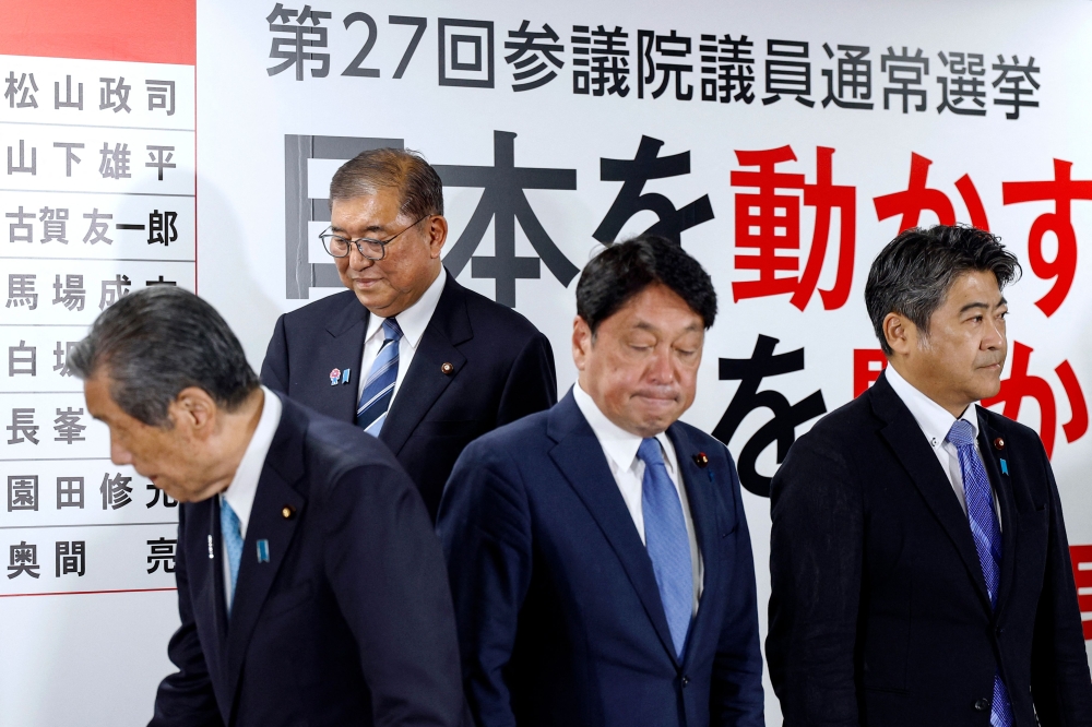 Japan’s Prime Minister Shigeru Ishiba (second from left) arrives for a media briefing following the upper house elections at Liberal Democratic Party (LDP) headquarters in Tokyo on July 20, 2025. — AFP pic
