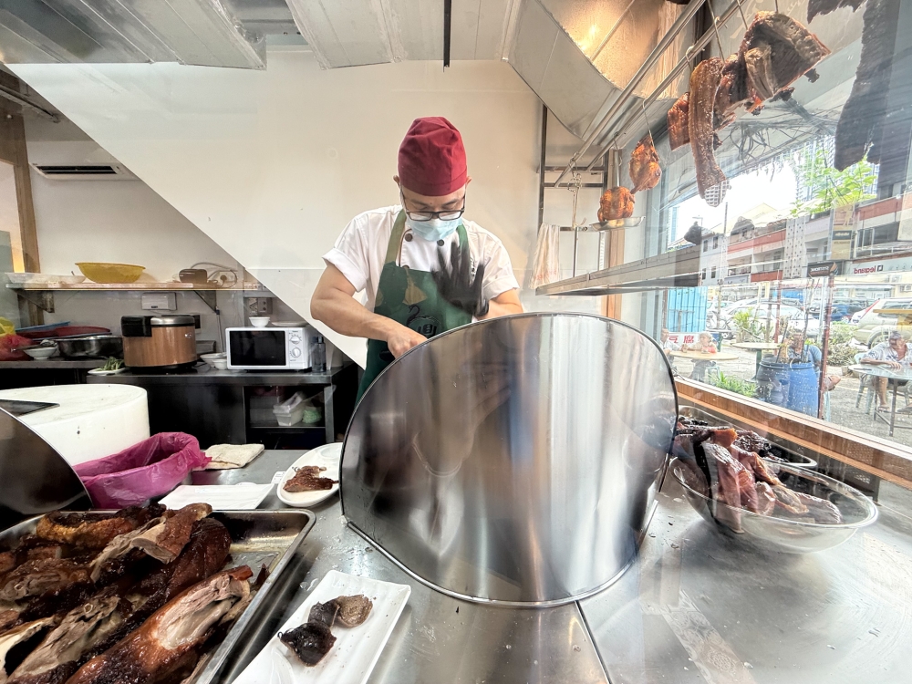 As you walk in, what grabs your attention is the mouthwatering sight of barbecued meat hanging for all to see. — Picture by Lee Khang Yi