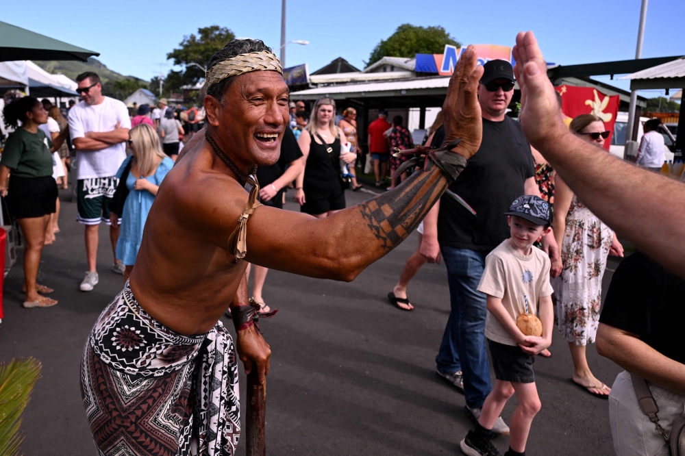 A photo taken on June 14, 2025 shows tour guide Ngametua Mamanu greeting tourists after speaking with AFP over the dangers to the environment created by deep sea mining in Rarotonga, Cook Islands. — AFP pic