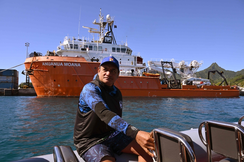 A photo taken on June 12, 2025 shows marine biologist Teina Rongo on his boat passing the research vessel MV Anuanua Moana in Rarotonga, Cook Islands. — AFP pic