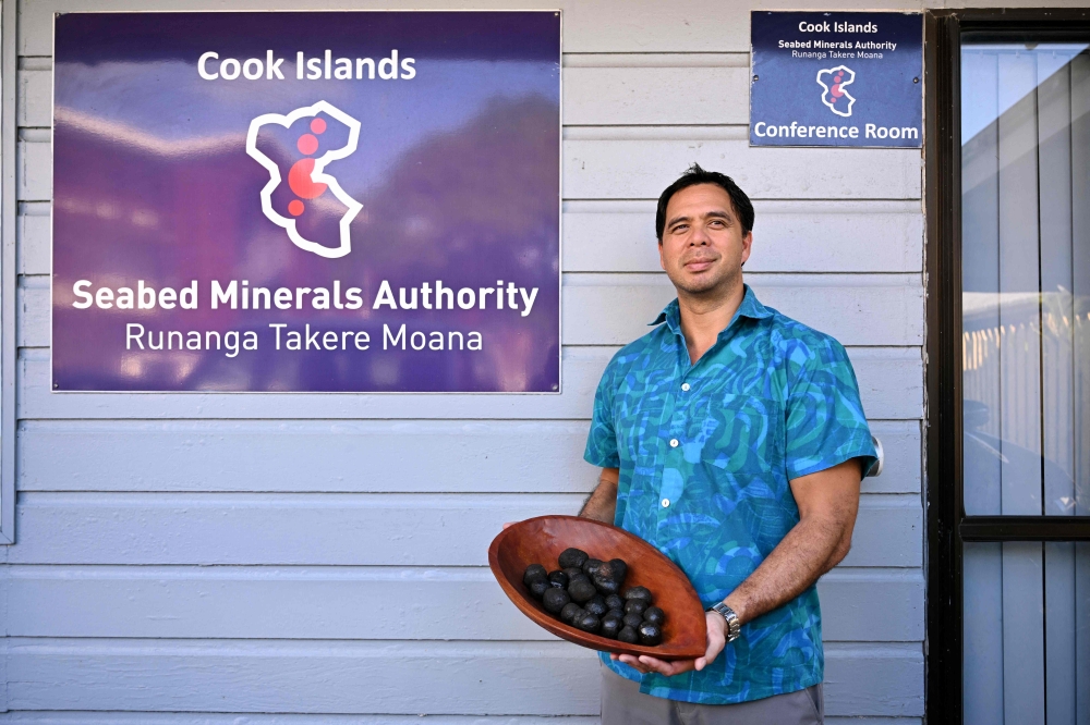 A photo taken on June 12, 2025 shows Edward Herman from the Cook Islands' Seabed Minerals Authority holding polymetallic nodules, misshapen black globes encrusted with cobalt, nickel, manganese and other coveted metals, after speaking with AFP about the future of deep sea mining and it's effects on the small Pacific nation, in Rarotonga, Cook Islands. — AFP pic