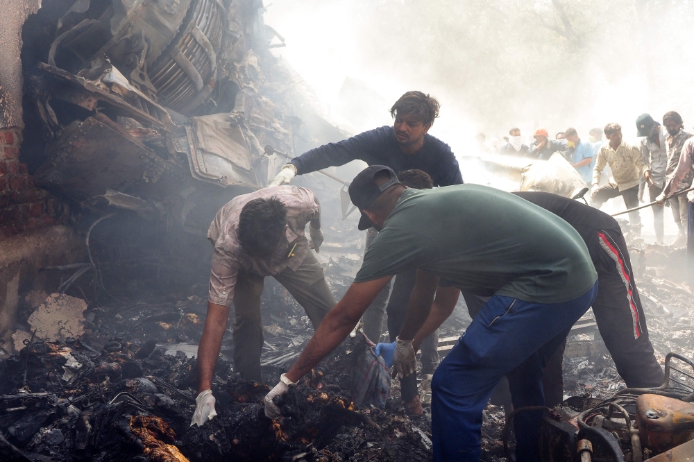 Rescue officials work at the site where Air India flight 171 crashed in a residential area near the airport in Ahmedabad June 12, 2025. — AFP pic