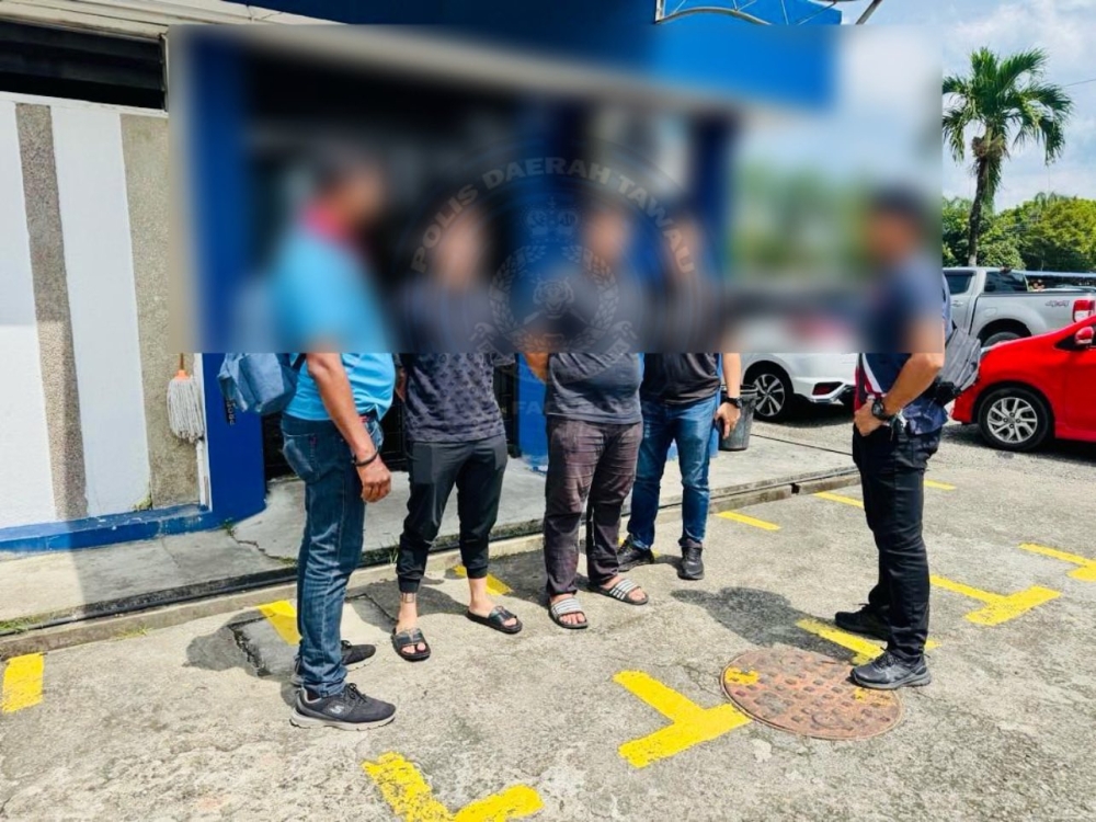 Four people detained for armed rioting are pictured outside the Tawau district police headquarters. — Royal Malaysia Police pic
