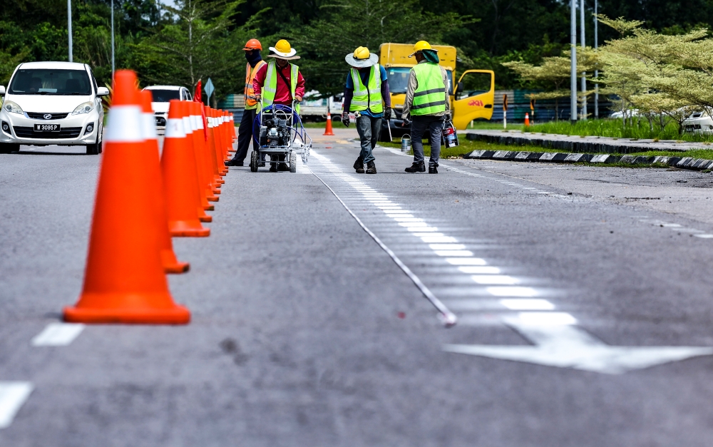 Workers are seen during roadworks in Kuching, on August 21, 2023. — Bernama pic