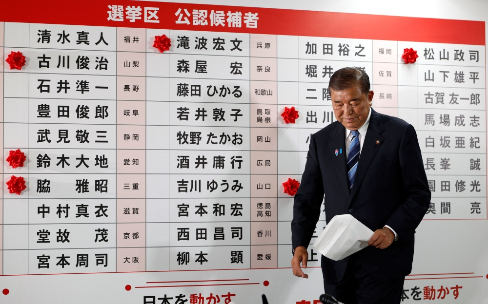 Shigeru Ishiba, Japan’s Prime Minister and president of the ruling Liberal Democratic Party (LDP), walks in front of a board with red paper roses showing elected candidates at the LDP headquarters, on the day of Upper House election, in Tokyo July 20, 2025. — Reuters pic