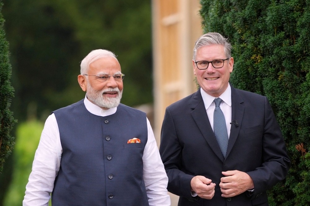 Britain's Prime Minister Keir Starmer (right) and India's Prime Minister Narendra Modi (left) speak as they walk in the gardens of Chequers, in Aylesbury, England July 24, 2025. — Kin Cheung/Pool/AFP pic
