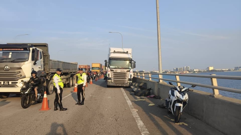 Traffic policemen direct vehicles at the scene of an accident at the Second Link on July 24, 2025. — Picture courtesy of Johor Fire and Rescue Department