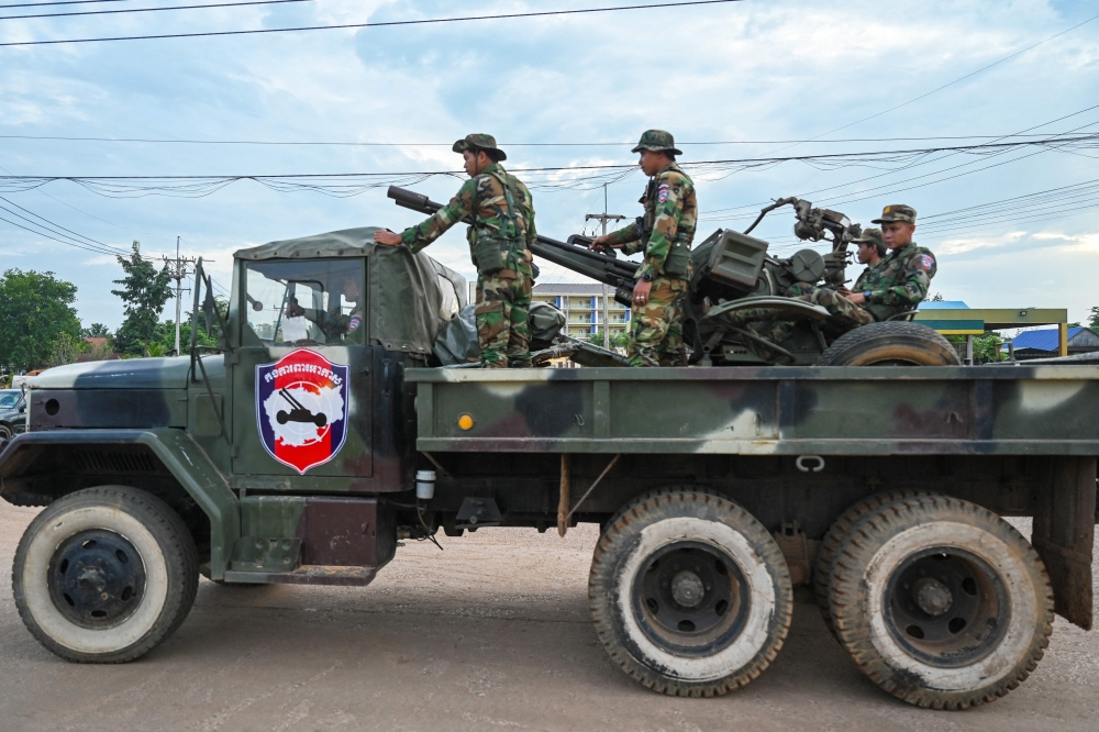 Cambodian soldiers stand on a military truck with an anti-aircraft gun in Oddar Meanchey province today. — AFP pic