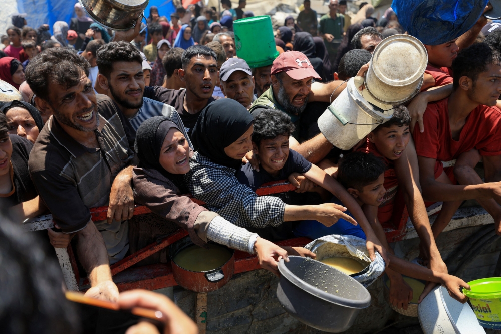 Palestinians gather to receive food from a charity kitchen, amid a hunger crisis, in Gaza City, July 25, 2025. — Reuters pic 