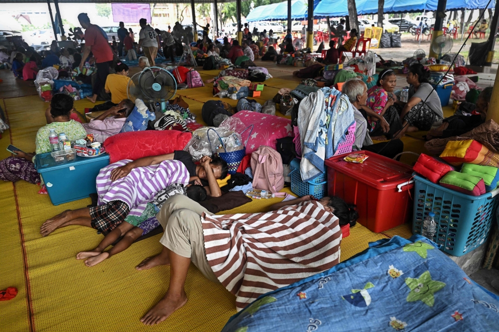 Evacuees displaced by the ongoing conflict between Thailand and Cambodia rest at a makeshift evacuation center inside a Buddhist temple in the Thai border province of Si Sa Ket July 26, 2025. — AFP pic 