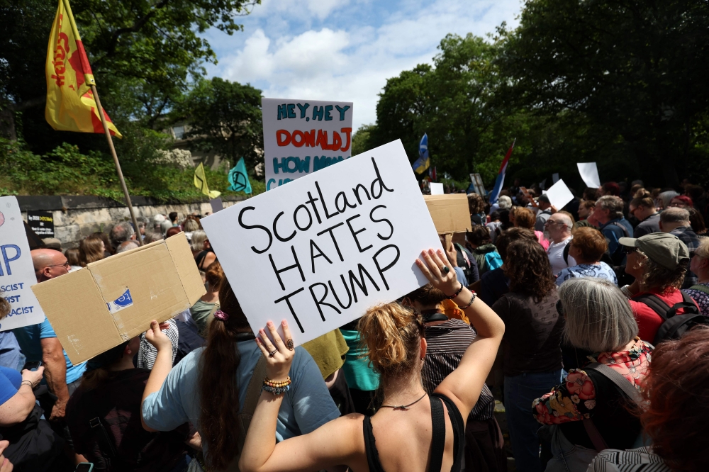 Demonstrators hold placards during a 'Stop Trump Coalition' protest near the US Consulate building in Edinburgh. — AFP pic
