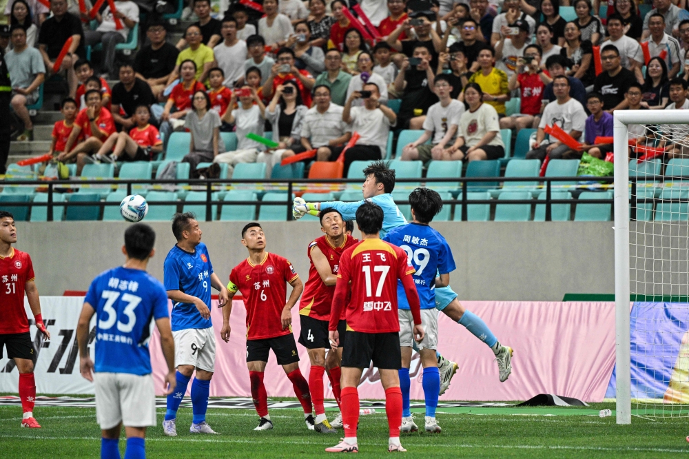 Amateur football teams Suzhou (red) and Yangzhou (blue) fight for the ball at the Kunshan Olympic Sport Centre in Kunshan June 29, 2025. — AFP pic