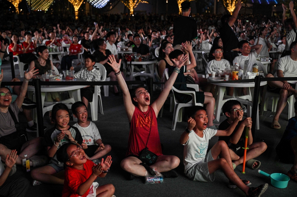Fans celebrate a goal of Suzhou amateur football team while watching the match on a screen showing the amateur league football match between Suzhou and Zhenjiang in the Shishan cultural square in Suzhou July 20, 2025. — AFP pic