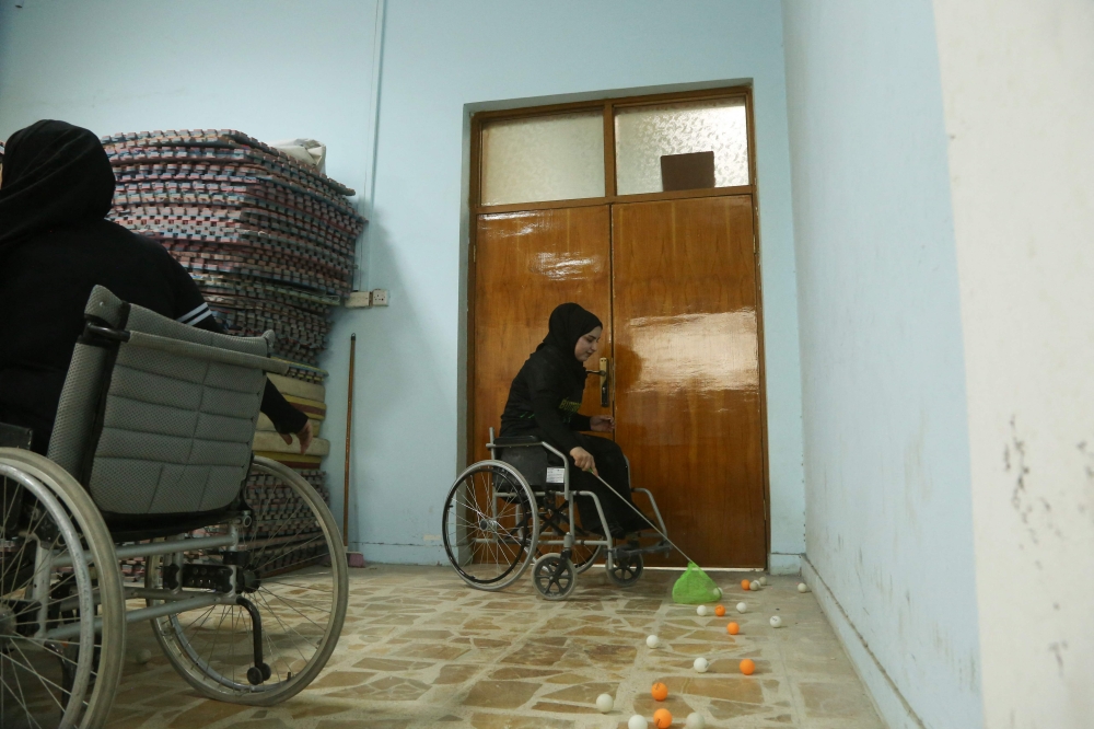Disabled Iraqi table tennis player Nur al-Huda Sarmad uses a net to pick up balls during a training session at a community centre in the southern city of Diwaniyah July 8, 2025. — AFP pic