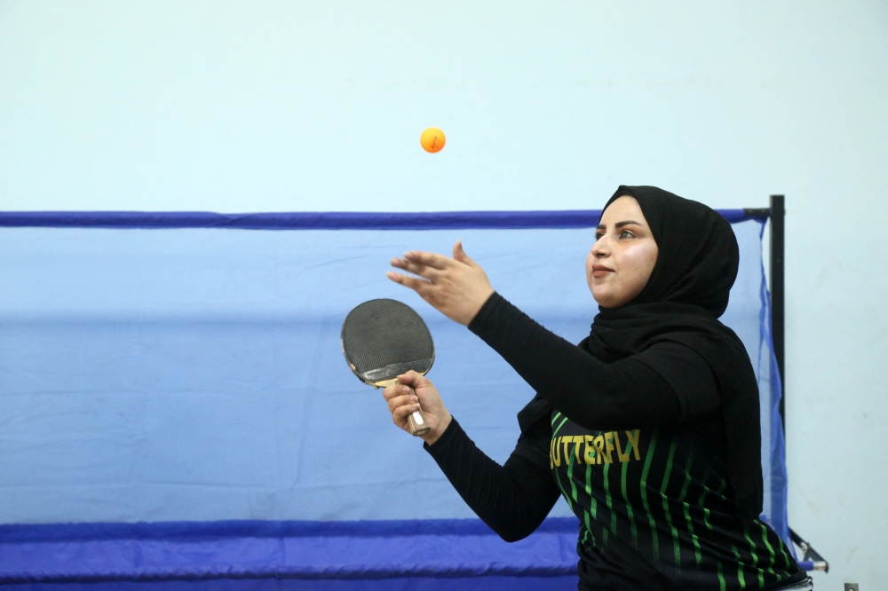 A disabled Iraqi table tennis player hits the ball during a training session at a community centre in the southern city of Diwaniyah July 8, 2025. — AFP pic