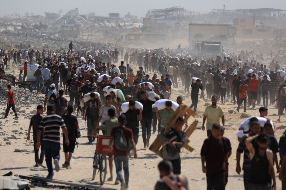 Palestinians carry aid supplies that entered Gaza through Israel, in Beit Lahia in the northern Gaza Strip July 27, 2025. — Reuters