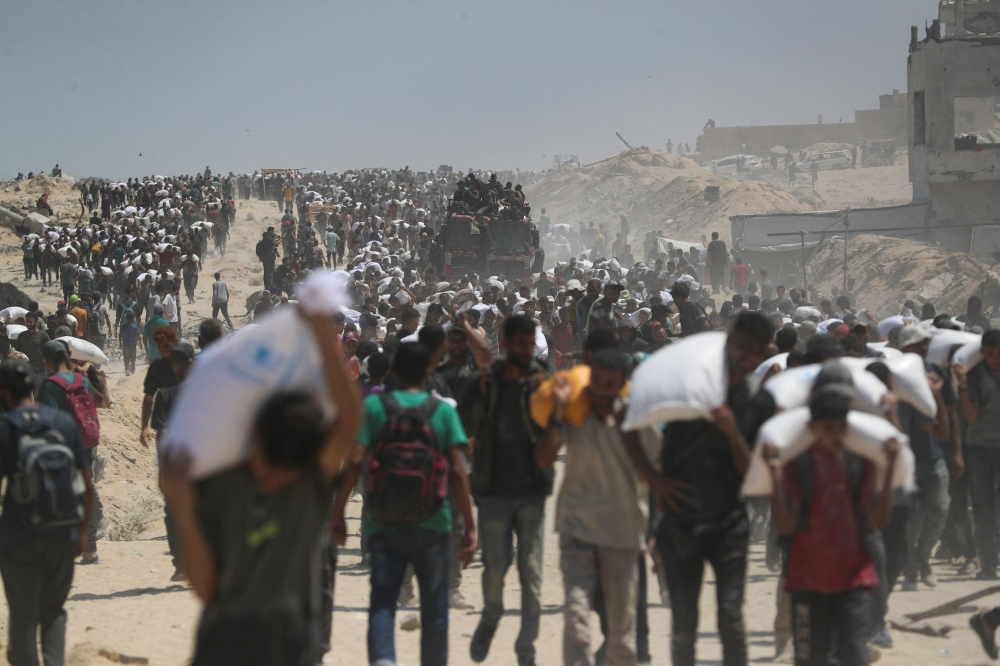Palestinians carry aid supplies that entered Gaza through Israel, in Beit Lahia, northern Gaza Strip, July 27, 2025. — Reuters pic 