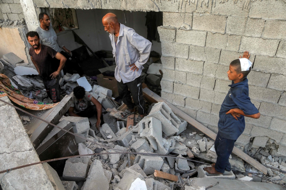 People inspect the rubble of a destroyed building in the aftermath of overnight Israeli bombardment in the Japanese neighbourhood in the northwest of Khan Yunis in the southern Gaza Strip on July 28, 2025. — AFP pic