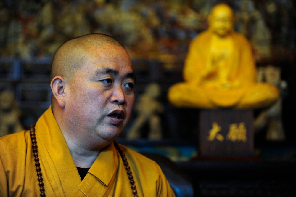 Shaolin Temple abbot Shi Yongxin faces allegations of embezzling temple funds, maintaining a fleet of luxury cars and fathering children with multiple women, and could be disrobed if found guilty. — AFP pic