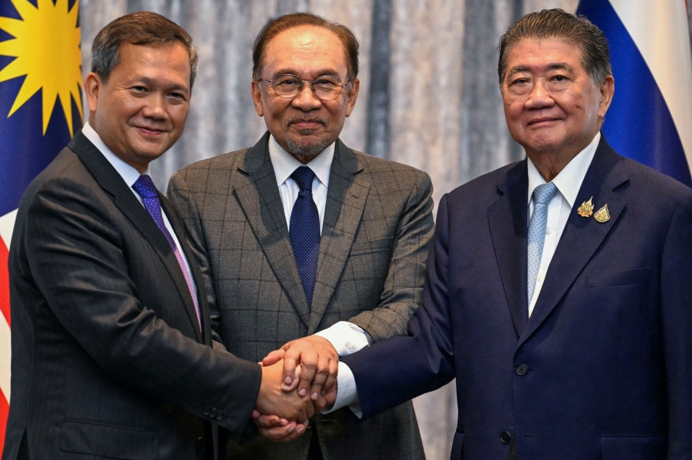 Cambodia’s Prime Minister Hun Manet, Malaysia’s Prime Minister Datuk Seri Anwar Ibrahim and Thailand’s acting Prime Minister Phumtham Wechayachai shake hands as they pose for photos following a press conference, on the day of mediation talks on the Thailand-Cambodia border conflict, in Putrajaya July 28, 2025. — Reuters pic