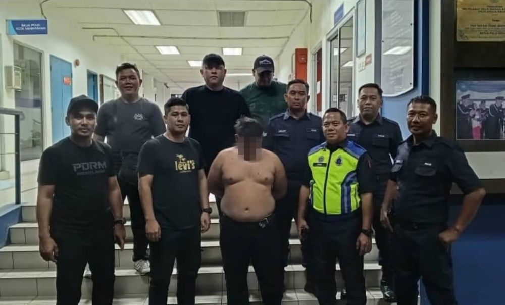 The suspect is seen with the police team. — Police handout via The Borneo Post