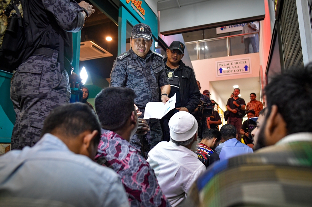 Immigration Enforcement Division director Basri Othman speaks to some of the 171 foreigners detained for various immigration offences during a raid in Jalan Masjid India, Kuala Lumpur July 29, 2025. — Bernama pic