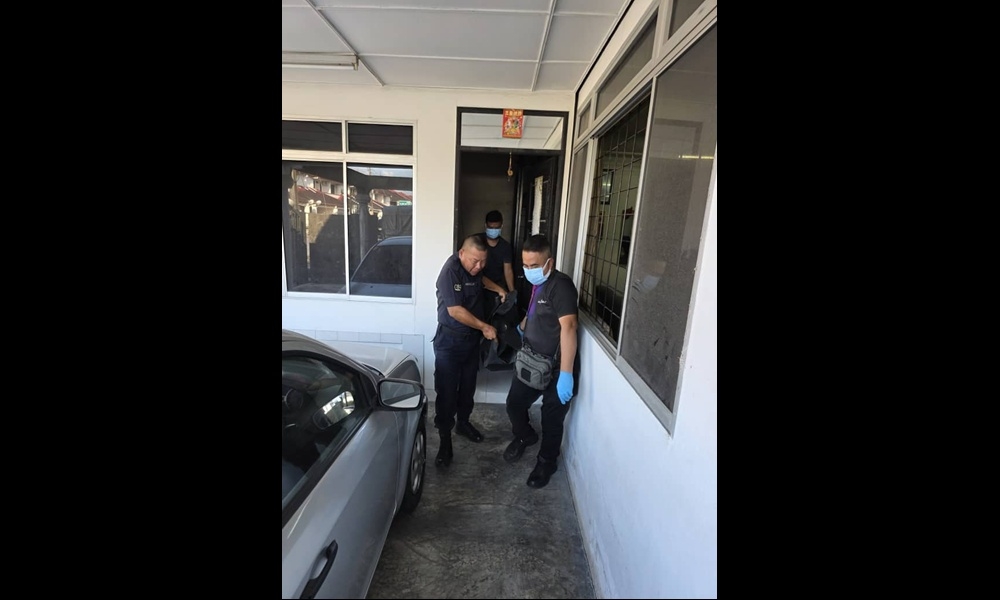 Police removing the victim’s body from the house in Taman Seng Goon in Kuching. — Picture courtesy of police