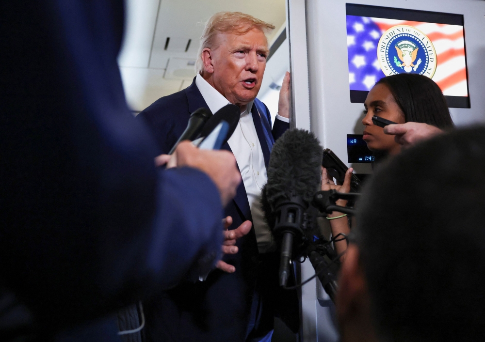 US President Donald Trump speaks to members of the media on board Air Force One en route from Scotland, Britain, to Joint Base Andrews, Maryland, July 29, 2025. — Reuters pic 