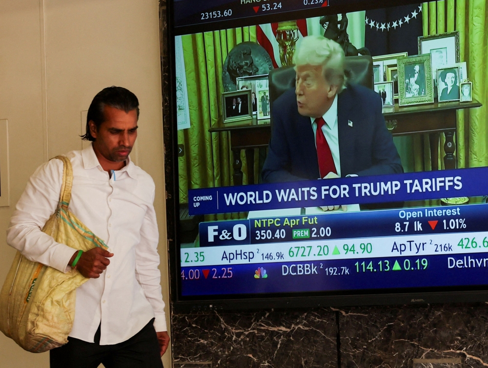 File picture of a man walking past a screen displaying US President Donald Trump, at the Bombay Stock Exchange (BSE) ahead of Trump’s tariff plans, in Mumbai, India, April 2, 2025. — Reuters pic 