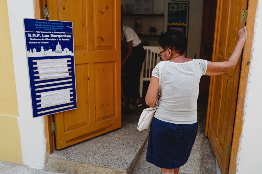 An older adult woman reads the menu at a community food center, part of the Family Attention System (SAF), in Havana, on May 26, 2025. — AFP