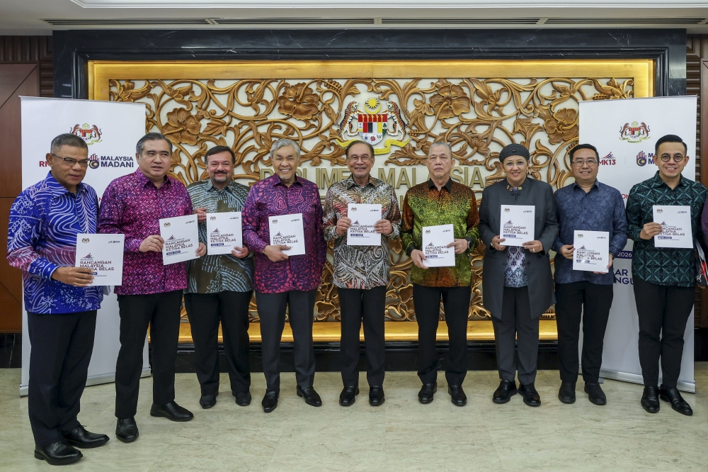 Prime Minister Datuk Seri Anwar Ibrahim and members of the Cabinet show the 13th Malaysia Plan (13MP) book at the Dewan Rakyat July 31, 2025. — Bernama pic