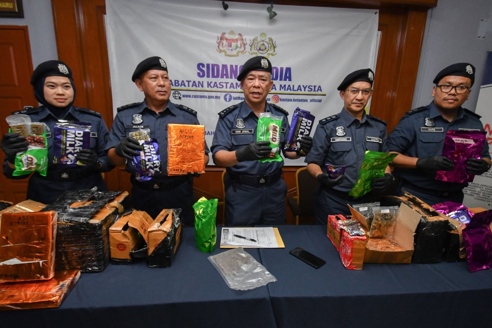 Kelantan Customs director Wan Jamal Abdul Salam Wan Long (centre) and officers show some of the compressed blocks suspected to be cannabis, seized from a courier service premises in Pengkalan Chepa, during a press conference in Kota Bharu July 31, 2025. — Bernama pic