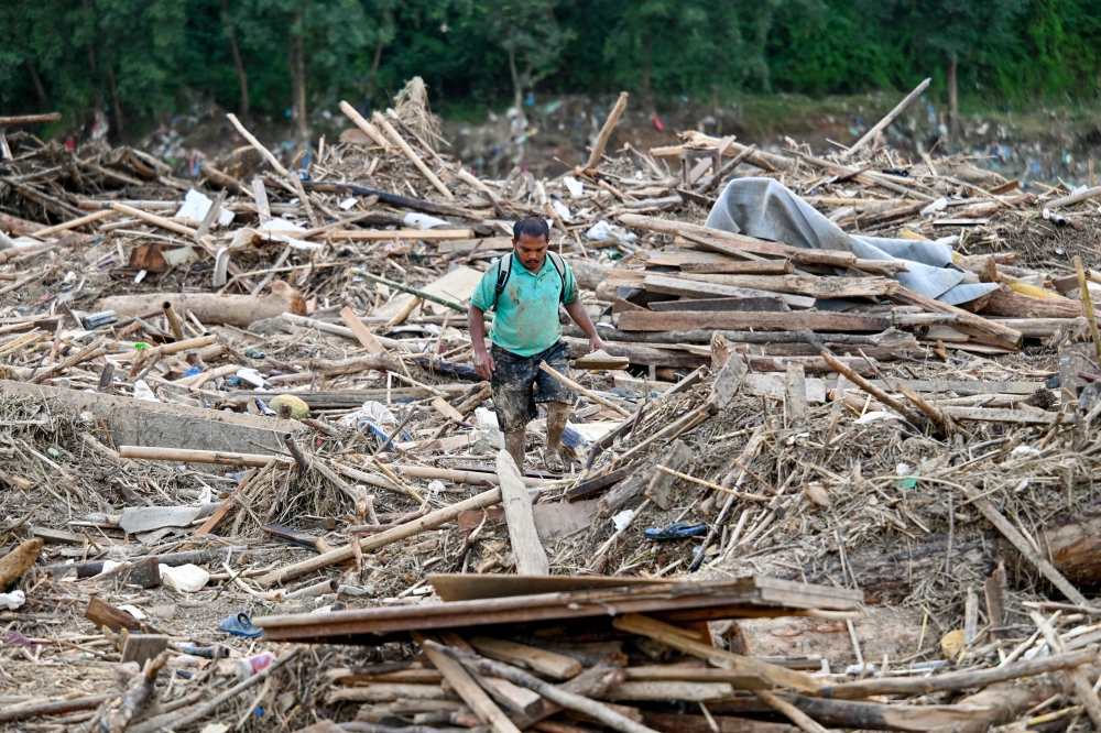 A man walks through a landslide-hit area after heavy rain in Lalitpur district, on the outskirts of Kathmandu October 1, 2024. Each year during the monsoon, floods and landslides wreak havoc across South Asia, with Nepal especially vulnerable due to unstable terrain, erratic rainfall and poor planning. — AFP pic