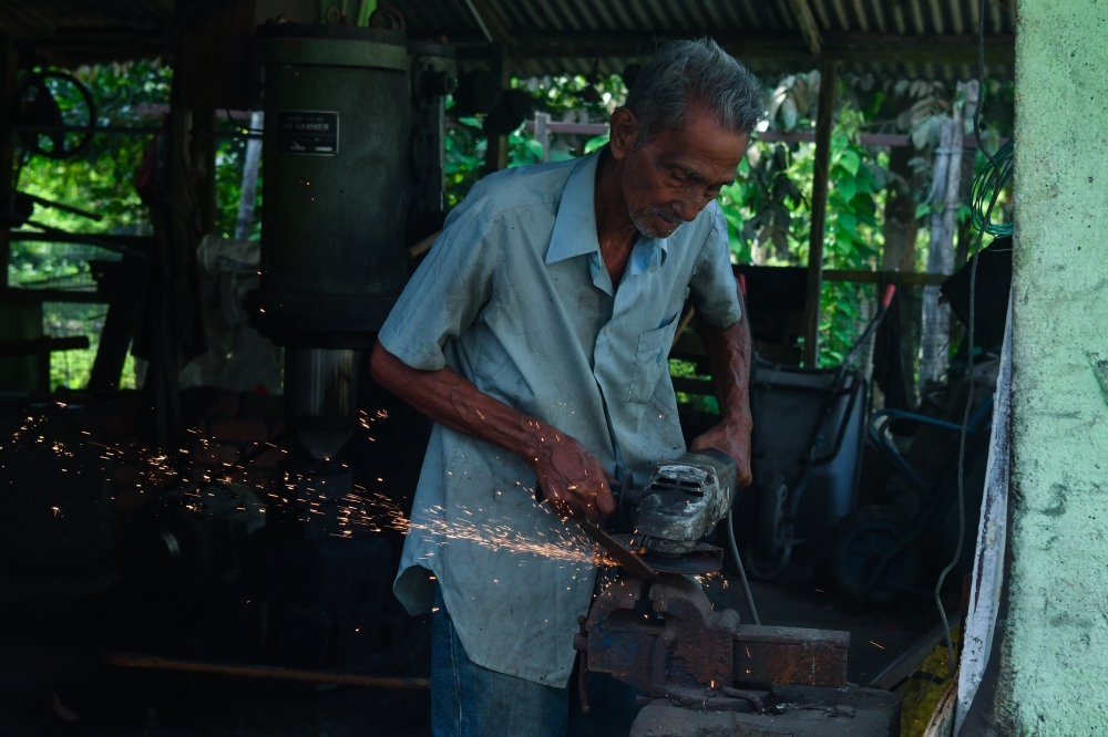 Knife maker Fauzi Yusoff works on refining a forged blade at his workshop in Kampung Hutan Pasir, Ketereh. — Bernama pic