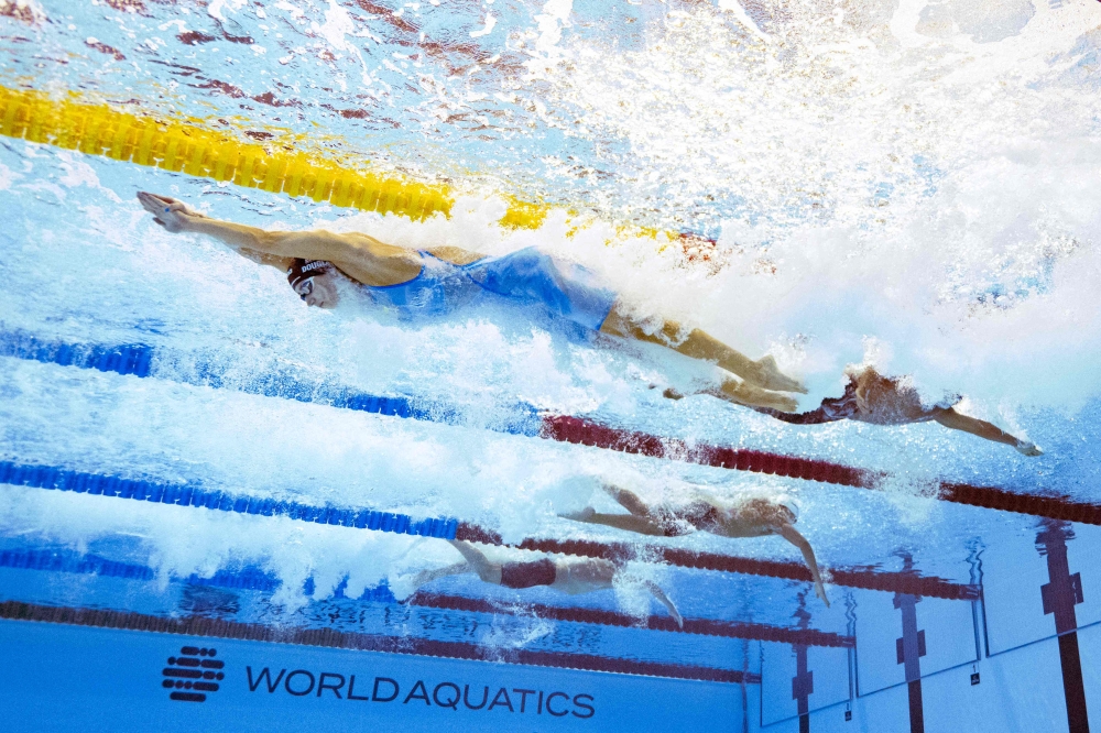 US’ swimmer Kate Douglass (top) competes in the final of the mixed 4x100m freestyle relay swimming event during the 2025 World Aquatics Championships in Singapore on August 2, 2025. — AFP pic